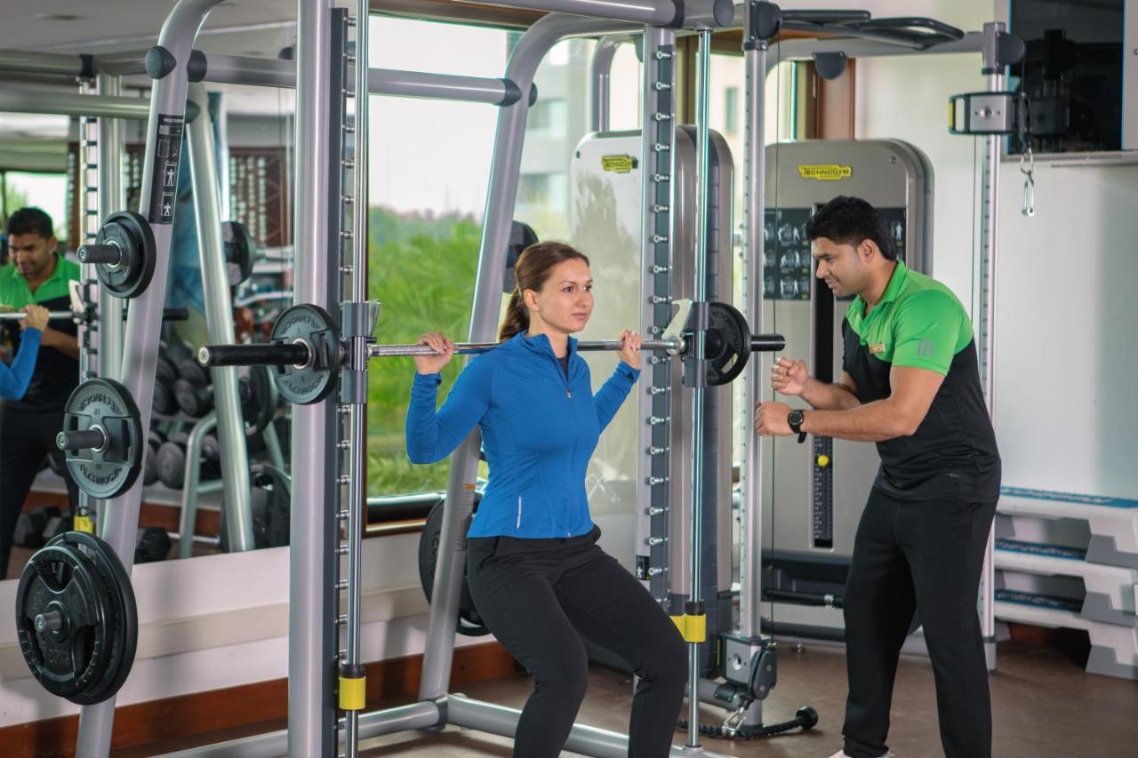 Jumeirah Messilah Beach Kuwait Kuwejt Zewnętrze zdjęcie A personal trainer assisting a woman with a squat
