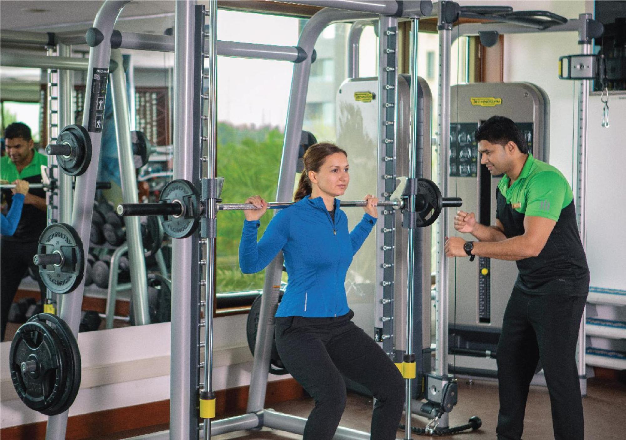 Jumeirah Messilah Beach Kuwait Kuwejt Zewnętrze zdjęcie A personal trainer assisting a woman with a weight training exercise